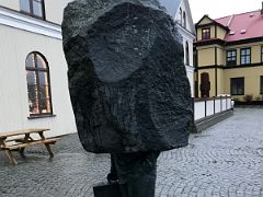 27 Sculpture of the unknown bureaucrat with a large slab of Icelandic volcanic basalt on top of legs with a briefcase by Magnus Tomasson 1994 Outdoor Art Reykjavik Iceland