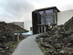 01C The path with a wall of black lava rocks on both sides leads to the entrance to the Blue Lagoon geothermal spa Iceland