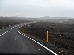 09A Driving west on road 425 thru a black lava field with the steam from Gunnuhver geothermal area in the distance Reykjanes Peninsula Iceland