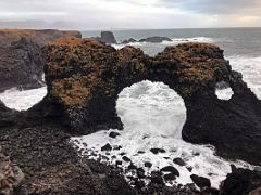 04A Gatklettur (Hellnar Arch) is a naturally formed stone arch carved from eroding wave action in Arnarstapi Snaefellsnes Peninsula Iceland