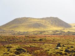 02B Green moss covered black lava, red soil and a crater in Berserkjahraun lava field Snaefellsnes Peninsula Iceland