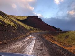03B Driving on dirt road 558 with an eroded red crater, green moss and pre-sunset red light in Berserkjahraun lava field Snaefellsnes Peninsula Iceland