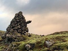04 A large cairn on the side of dirt road 558 with green moss covered black lava in Berserkjahraun lava field Snaefellsnes Peninsula Iceland