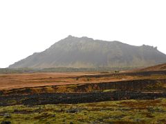 01B Looking back at road 574 and Stapafell mountain across the green moss covered lava from Raudfeldar canyon ravine on Snaefellsnes Peninsula Iceland