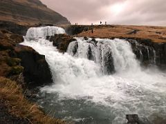 06B People walk around the two Kirkjufellfoss waterfalls near Grundarfjordur Snaefellsnes Peninsula Iceland