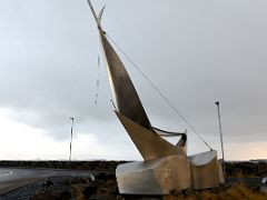 04B A Heimleid sculpture by Grimur Marino Steindorsonn 1994 is a sailboat made of stainless steel Stykkisholmur harbour Snaefellsnes Peninsula Iceland