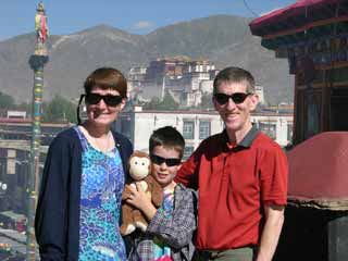 Charlotte Ryan, Dangles, Peter Ryan, and Jerome Ryan on the roof of the Jokhang Temple in Lhasa, with the Potala Palace behind