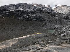 01C The Tents Of Carstensz Pyramid Base Camp Are Set Up Near A Small Lake With Ngaa Polu Above Right