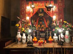 12A Pao Kung god of justice Taoist statue surrounded by flowers and fruit offerings at Man Mo Temple Hong Kong