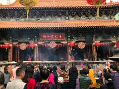 06A People offer incense joss sticks outside the main hall at Wong Tai Sin temple Hong Kong