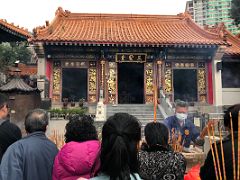 08A People offering incense joss sticks at Three Saints Hall for the worship of Lu Dongbin, Guanyin, Guandi at Wong Tai Sin temple Hong Kong