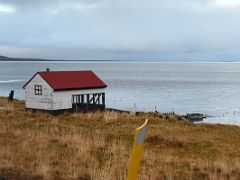 03A A lone building with a red roof on the Seljafjordur coast driving to Grundarfjordur Snaefellsnes Peninsula Iceland