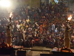 07B Two Brahmins Hold A Lamp High With Flames Shooting Into the Air Before The People Seated On The Ghat Steps In The Ganga Aarti Fire Ceremony On The Banks Of The Ganges Varanasi India