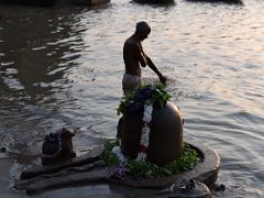 05A A Hindu Pilgrim Bathes In The Holy Ganges River With Nandi The Bull And Shiva Lingam On The Shore Of The Manikarnika Burning Ghat Varanasi India