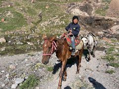 04A A young boy on a horse offers to let me ride his second horse next to the river on hike to Tulpar Lake from Ak-Sai Travel Lenin Peak Base Camp 3600m