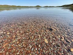 07A The crystal clear water of Tulpar Lake stretches into the distant green hills on day hike from Ak-Sai Travel Lenin Peak Base Camp 3600m