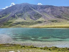 07B The light green and dark green colours of Tulpar Lake stretches to the reddish hill beyond on day hike from Ak-Sai Travel Lenin Peak Base Camp 3600m