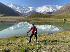 02A Jerome Ryan next to a small lake with a reflection of Lenin Peak and other mountains on the day hike to Pik Petrovski from Ak-Sai Travel Lenin Peak Base Camp 3600m