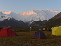 09A The first rays of sunrise burn Unity Peak, Pik Spartak and Lenin Peak orange with the tents of Ak-Sai Travel Lenin Peak Base Camp 3600m