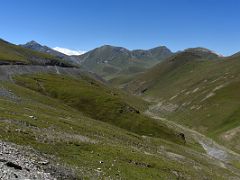 11A View of the Pamir Highway ahead with Lenin Peak poking above the surrounding hills from Taldyk Pass 3615m on the way to Lenin Peak Base Camp