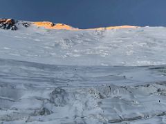 05C The first rays of sunrise shine the Lenin Peak summit ridge orange after leaving crampon point on the way to Ak-Sai Travel Lenin Peak Camp 2 5400m