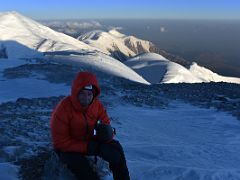 04A Resting and eating a gel with Dzerzhinsky Peak, Pik Krasina, Pik Tsyurupy, Camp 3 on Razdelnaya Peak beyond in early morning light on the way to the Lenin Peak summit