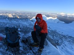 04C Resting and eating a gel with many mountains beyond in early morning light on the way to the Lenin Peak summit