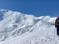 06C Jerome Ryan arrives on the snowy windy summit of Yuhin Peak 5100m with Lenin Peak beyond near Ak-Sai Travel Lenin Peak Camp 1 4400m