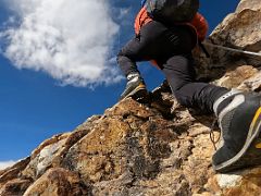 10C Climbing the traverse to the ridge on steep red rocky boulder slabs with hand ropes on the way to Lobuche East High Camp 5600m