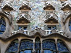 01B Casa Batllo has irregular oval windows, flowing sculpted stone work and has a colourful mosaic made of broken ceramic tiles by Antoni Gaudi Barcelona Spain