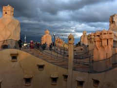 11A Sunset on stairwell chimney covers, chimney ventilation shafts and the curved building from Roof La Pedrera Casa Mila Gaudi Barcelona Spain