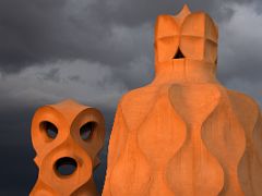 11C Sunset on ventilation tower with openings looking like an alien with eyes and mouth and stairwell tower Roof La Pedrera Casa Mila Gaudi Barcelona Spain