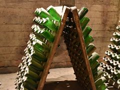 12B Old bottles in am old wine rack in the underground tunnels Codorniu Penedes wine tour near Barcelona Spain