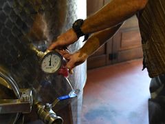 17C Felix pours wine directly from a metal barrel at Felix Massana Rafols organic winery in Penedes wine tour Near Barcelona Spain