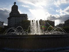 02A The water of a fountain are silhouetted by the setting sun in Placa Catalunya Barcelona Spain