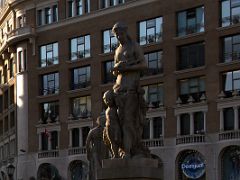 03C Statue of Woman with Boy by Josep Viladomat 1928 She cradles a flute at waist level and on her right side is a naked boy in Placa Catalunya Barcelona Spain