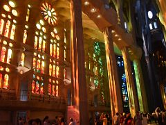 21B The afternoon sun shines through the stained glass windows on the west side with reds, oranges and yellows Sagrada Familia Barcelona Spain