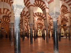 04A Columns stretch geometrically with alternating red and white voussoirs of the arches in the Mezquita Mosque Cordoba Spain