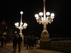 05A Old style streetlights in the shape of a candelabra on La Concha Promenade With Londres Hotel Beyond At Night San Sebastian Donostia Spain