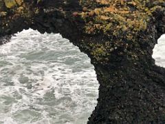 04C The two openings in the Gatklettur (Hellnar Arch) naturally formed stone arch in Arnarstapi Snaefellsnes Peninsula Iceland