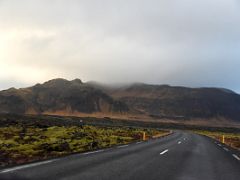 01B Road 54 snakes thru green moss covered lava with Bjarnarhafnarfjall mountain towards Grundarfjordur on Snaefellsnes Peninsula Iceland