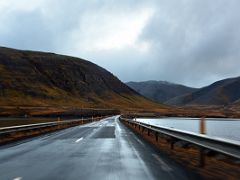 02C Driving on Road 54 across a causeway on Seljafjordur inlet with Gjafi mountain to left and Kolgrafamuli mountain to right driving to Grundarfjordur Snaefellsnes Peninsula Iceland