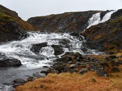 05B A waterfall enters the Straumfjardara River and tumbles over rapids next to Road 56 on Snaefellsnes Peninsula drive to Stykkisholmur Iceland