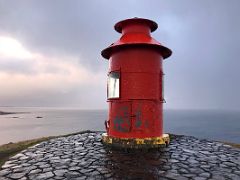 09A The red lighthouse on top of the basalt island Sugandisey with a view to Breidafjordur Bay Stykkisholmur harbour Snaefellsnes Peninsula Iceland