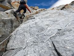 09A Climbing the steepest section of the rocky boulder slabs with hand ropes on the way to Lobuche East High Camp 5600m