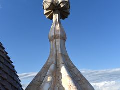 14C A tower has a cross of four arms and a bulbous, root-like structure that evokes plant life roof terrace Casa Batllo Gaudi Barcelona Spain