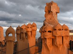 11B Sunset on ventilation chimneys looking like lines of warriors turned to stone and stairwell chimney Roof La Pedrera Casa Mila Gaudi Barcelona Spain