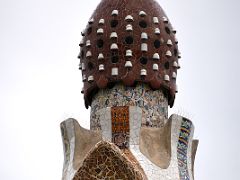 08D Casa del Guarda Porters Lodge roof is topped by what looks like a pine cone covered with trencadis, a mosaic made of tile shards Park Guell Barcelona Spain