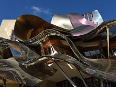 02B Marques de Riscal Frank Gehry 2006 facade pink hues of Rioja, silver foil shielding the cork, and gold mesh which adorns Marques de Riscal wine bottles Spain